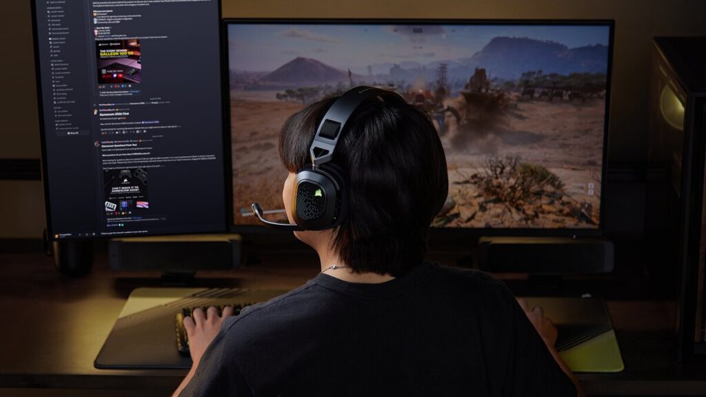 Gracz w słuchawkach Corsair HS80 v2 MAX Wireless przy komputerze