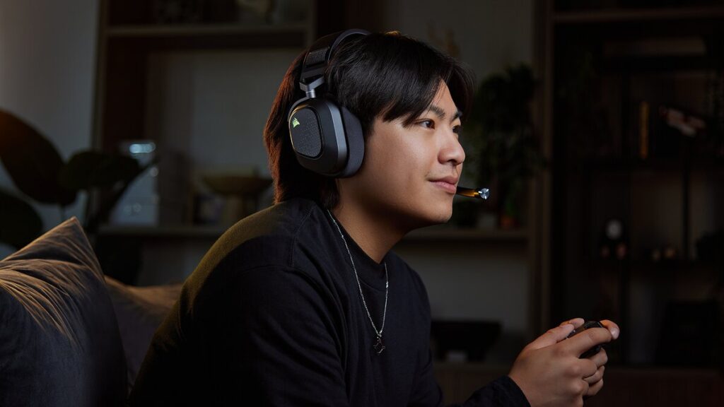 Gracz z padem w słuchawkach Corsair HS80 v2 MAX Wireless